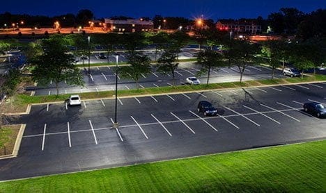 The image depicts commercial exterior LED lighting installed in a parking area.