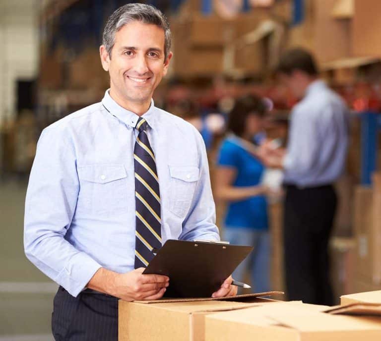 The image shows a portrait of a manager in a warehouse.