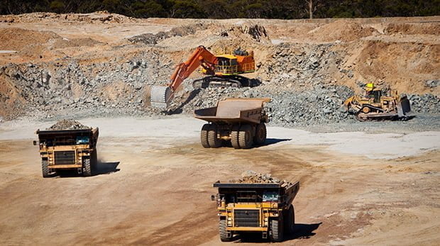 Coal mining pit with large equipment for digging and trucks for tranasporting raw coal for processing