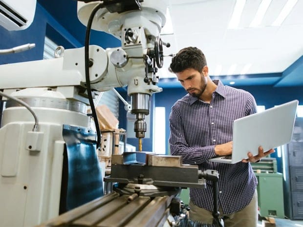 Engineer calibrating a large drill equipment